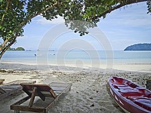 Sunbed and kayak on the beautiful shore of the azure sea and white sand - copy space