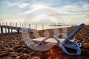 Sunbed on the sand beach and view to water of sea, pierce and blue sky with white clouds in a nice day, morning or evening. The