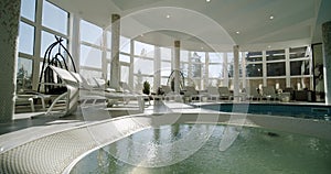 Sunbeds in the indoor swimming pool. Move camera