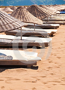 Sunbeds and parasols on sandy beach.