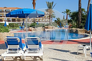 sunbeds by the pool on nature near the sea background