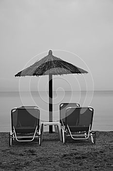 Sunbeds and straw beach umbrella