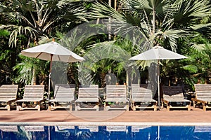 Sunbeds beside swimming pool in tropics