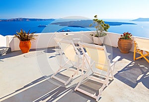 Sunbeds on the terrace of hotel. Santorini island, Greece. Beautiful summer landscape with sea view