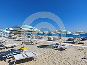 Sunbeds and umbrella on sunny day at the beach