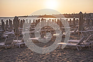 Sunbeds and umbrellas on the beach at sunset