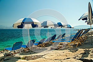 Sunbeds and umbrellas (parasols) on the beach in Corfu Island, Greece
