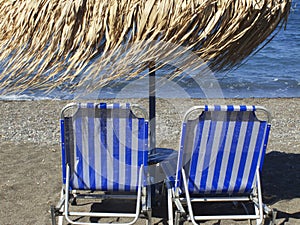 Sunbeds at Vlichada beach, Santorini, Greece.