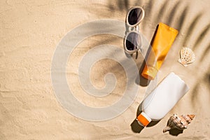 Sunblock lotion bottles on sandy beach