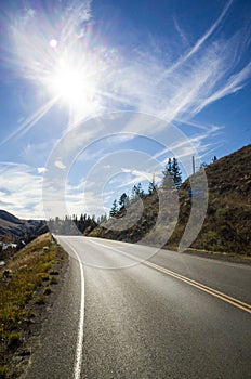 Sunburst above an empty tarred road