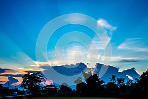 Sunburst behind the clouds with blue sky background