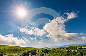 Sunburst on a blue sky with clouds over the mountains