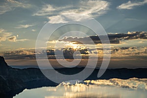 Sunburst Breaks Through Dark Clouds Over Crater Lake Just After Sun Rise