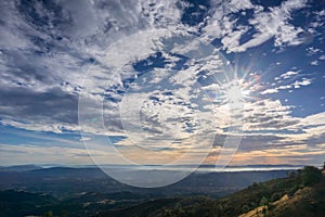 Sunburst and cloudscape above the hills and valleys of Contra Costa county