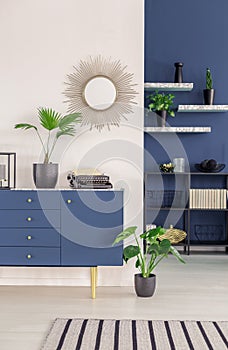 Sunburst mirror above blue sideboard