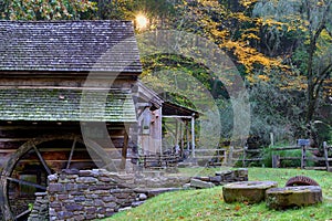 Sunburst at sunrise with old historic grist mill in the foreground in the fall