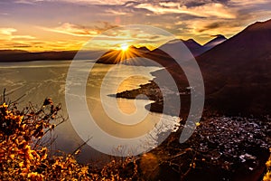 Sunburst at sunrise over Lake Atitlan & 5 volcanoes, Guatemala