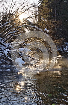 Sunburst in winter with flowing river