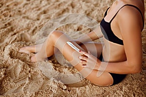 Suncream. Suntan Lotion Beauty Woman Applying on beautiful sexy legs Sunscreen Solar Cream.