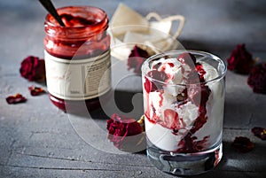 Sundae Ice cream with cherry in chocolate topping, and dried rose flowers on dark background. Love, Valentine`s day