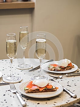 Sunday brunch with prosecco and eggs and salmon bruschetta on marble table