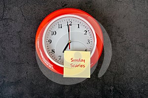 Sunday scaries text on adhesive note on top of clock
