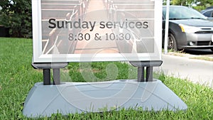 sunday services 830 and 1030 time sign information on grass lawn next to curb 40 v