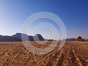 Sundown, mountains and red sand in Wadi Rum. Safari ride on a pick up trucks in Arabian desert.