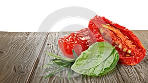 Sundried tomatoes with herbs on wooden table photo