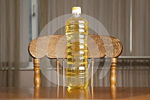 Sunflower, jug of oil and seeds on wooden table against white background