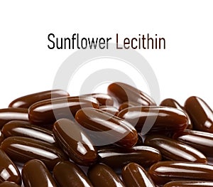 Sunflower lecithin in capsules on a white background. Lecithin in brown capsules top view. Food supplements close-up