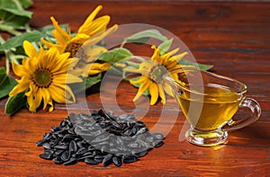 Sunflower oil in a glass gravy boat, and a handful of sunflower seeds