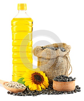 Sunflower oil in plastic bottle, seeds and flower on white background