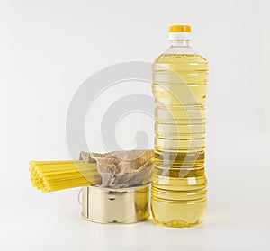 sunflower oil in a plastic bottle, spaghetti and a tin can with stew on a white background.