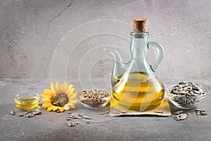 Sunflower oil and sunflower seeds on dark concrete background with copyspace