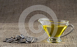 Sunflower seed oil in a glass gravy boat and a handful of sunflower seeds