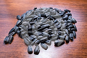 Sunflower seeds lying on the wood table. Blurred background.