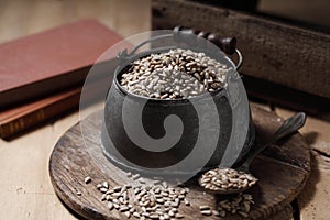 Sunflower seeds in measuring cup on the wooden background