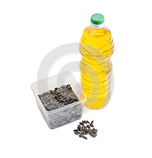 Sunflower seeds in plastic tray and bottle of sunflower oil