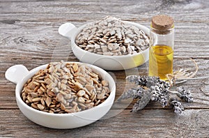 Sunflower seeds raw and roasted with a bottle of sunflower oil. photo