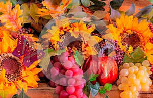 Sunflowers, grapes, and a pumpkin glows in the morning sun on a mantel