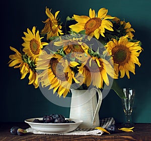Sunflowers and plums. bouquet of garden flowers and berries