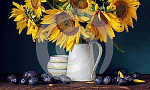 Sunflowers and purple plums. flowers and fruit