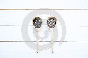 Sunflowers seeds in spoon on white wooden table