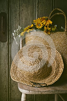 Sunflowers in straw purse on chair