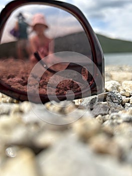 Sunglasses on the beach, lie on the sandy sand at sunset. Concept of beach holiday, serenity