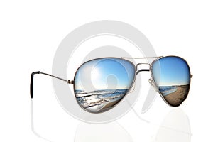 Sunglasses with beach reflection over white