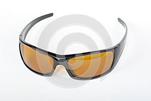 Sunglasses with black plastic frame and yellow glass on a white background