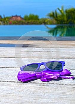 Sunglasses and bow tie near the pool