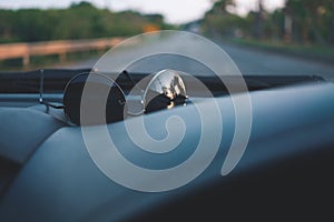 Sunglasses on car panel with view of road while traveling